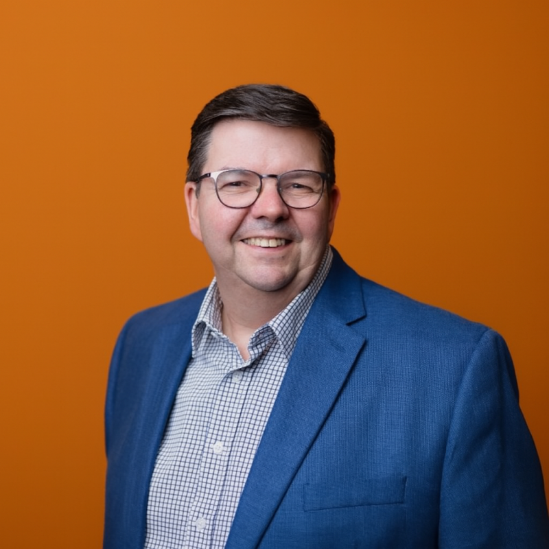 Headshot of Gordon Campbell against an orange background
