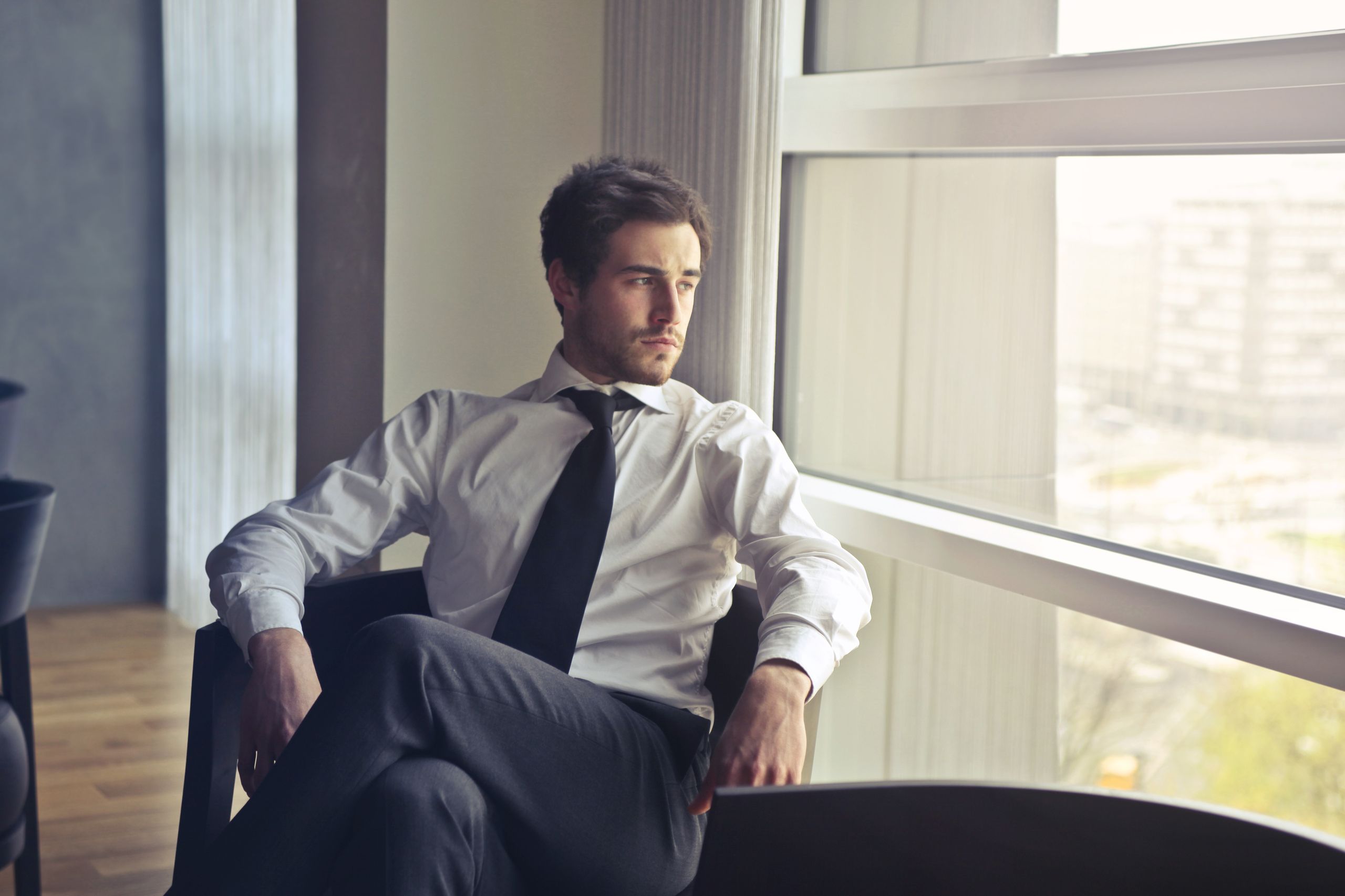 Photo of a businessman thinking by an office window