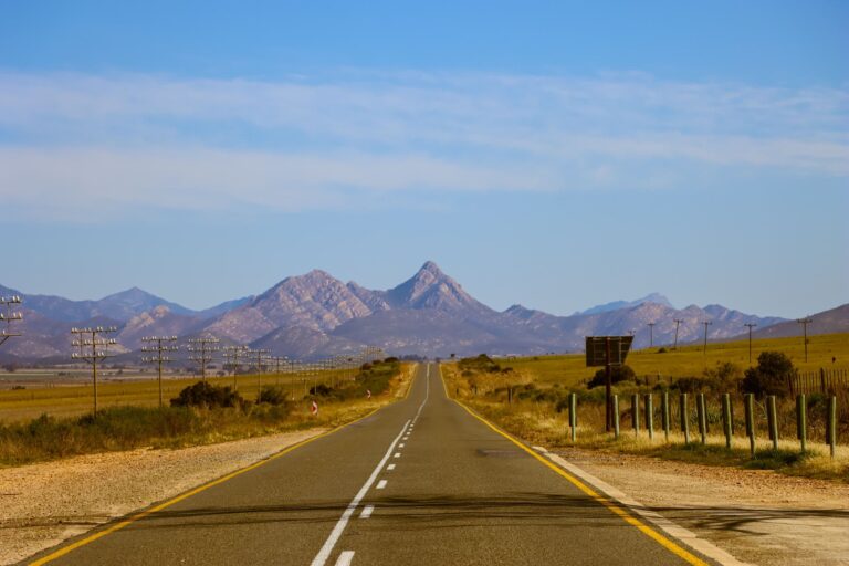Photo of an open road leading towards mountains