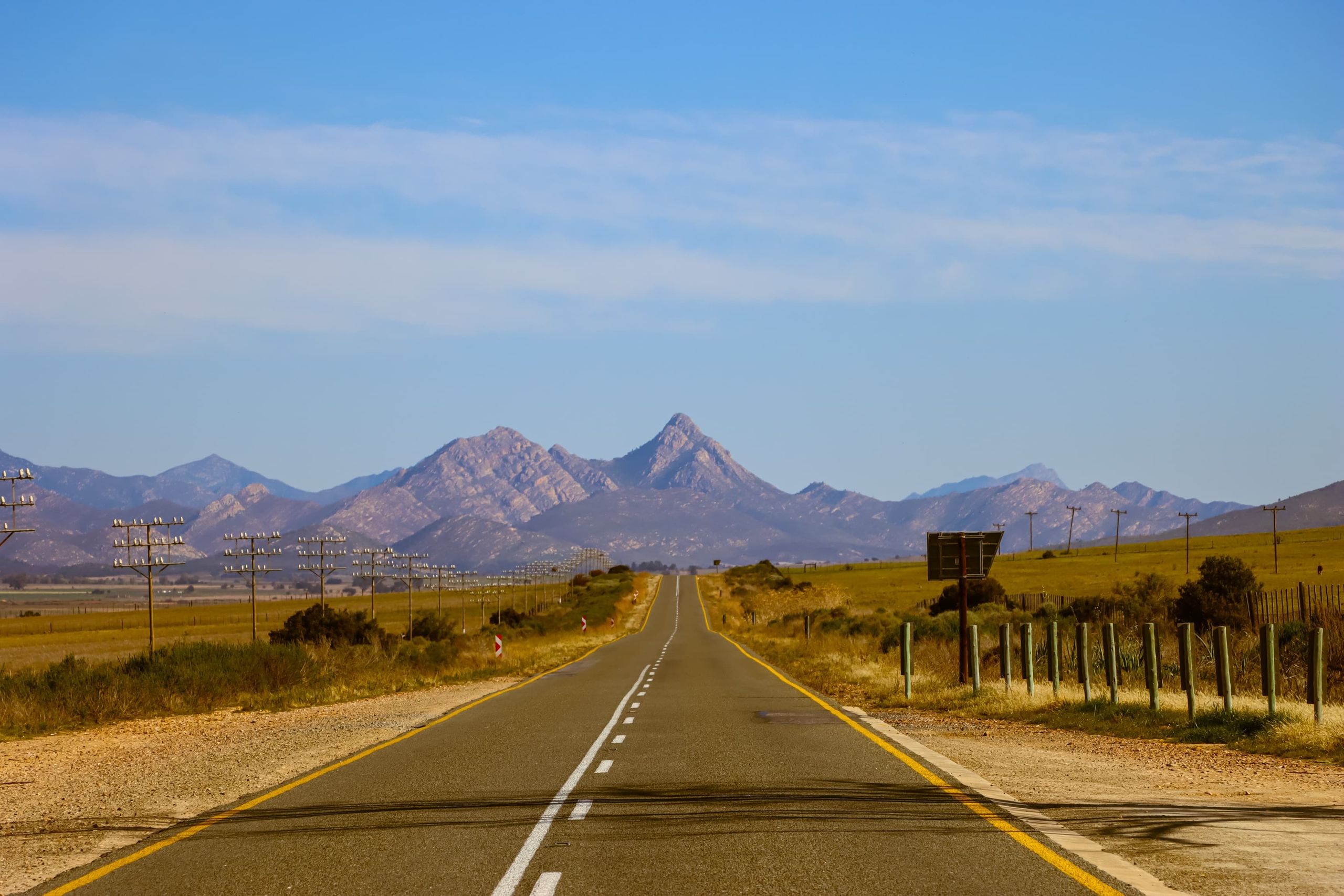 Photo of an open road leading towards mountains