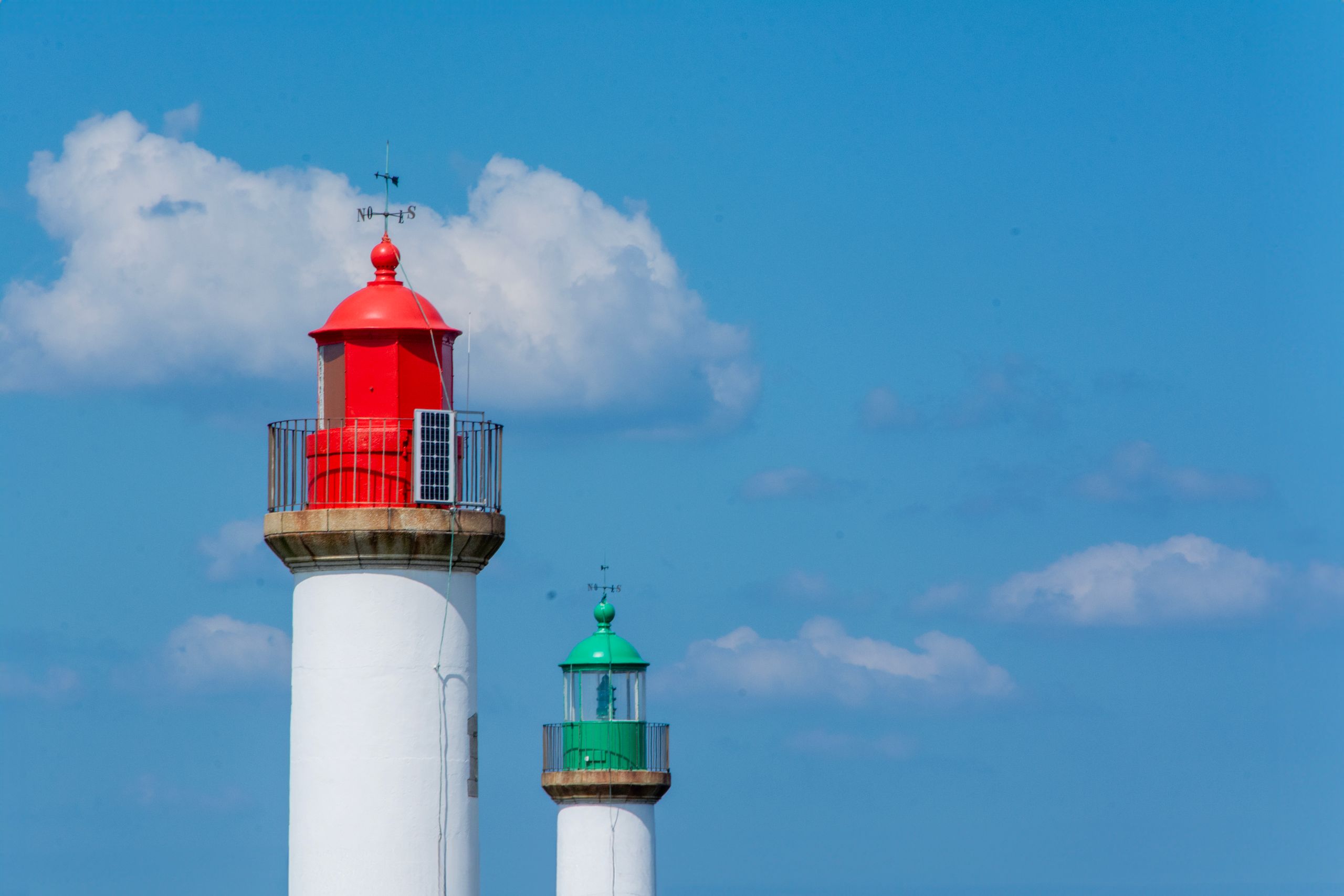Photo of two lighthouses under a blue sky