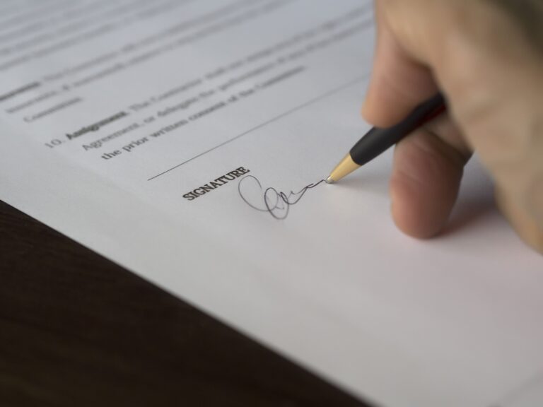 Photo of a hand signing a contract