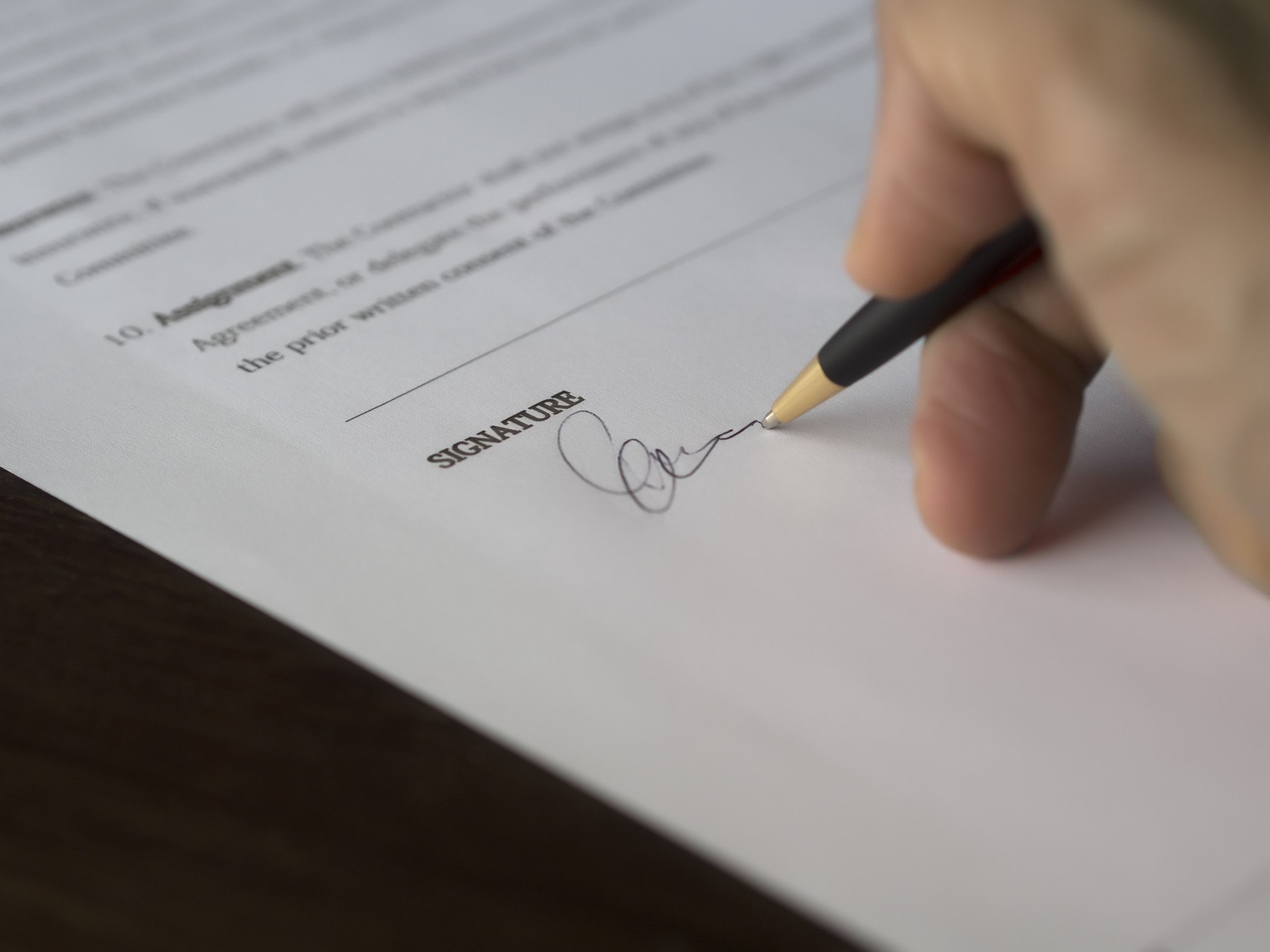 Photo of a hand signing a contract